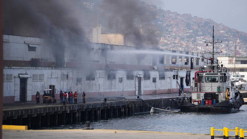 Smoke rises from a dock after explosions were heard at La Guaira port, Venezuela, Saturday,...