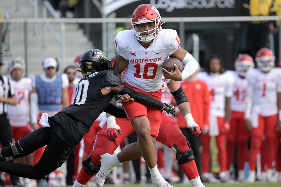 Houston quarterback Ui Ale (10) is tackled by Central Florida defensive back Quadric Bullard...