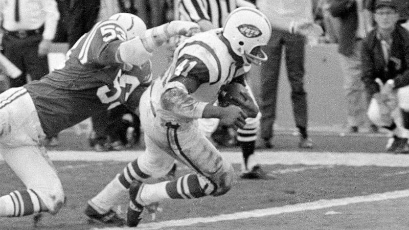 FILE - New York Jets fullback Matt Snell, center, runs the ball as Baltimore linebacker Dennis...